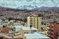 Picture of the urban area on the hill against mesmerizing snow-peaked mountains