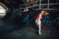 A picture of well-built rollerblaider riding backwards. She is looking back careful. Girl is smiling. Her hair is waving.