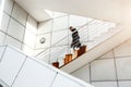 Picture of white steel staircase with blurred man going down.