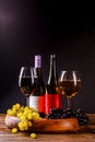 Picture of wine glass with wine, grape black, green on wooden tray on table