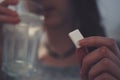 Woman eating sugar and drinking water to treat a sugar low (hypo)