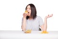 picture of woman with fruits and hamburger in front on white background, healthy versus junk food concept