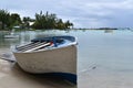 Picture of a wooden boat stranded on a tropical beach with in the background a view of the bay with many boats at the anchorage. Royalty Free Stock Photo