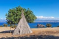 Picture of wooden wickiup like building with blue sky and clouds at the background Royalty Free Stock Photo