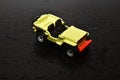 Children`s toy yellow jeep on a dark background