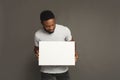 Picture of young african-american man holding white blank board Royalty Free Stock Photo