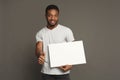 Picture of young african-american man holding white blank board Royalty Free Stock Photo