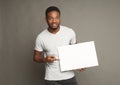 Picture of young african-american man holding white blank board Royalty Free Stock Photo