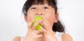 Picture of a young Asian girl with black hair eating healthy green apple fruit and vitamin C for diet or diet in the white Royalty Free Stock Photo