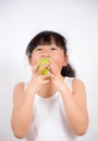 Picture of a young Asian girl with black hair eating healthy green apple fruit and vitamin C for diet or diet in the white Royalty Free Stock Photo