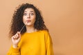 Picture of a young attractive lady dressed in casual standing isolated over beige background stretching bubble gum. Look at camera Royalty Free Stock Photo