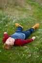 Picture of young beautiful blond man laying on green grass among Royalty Free Stock Photo