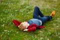 Picture of young beautiful blond man laying on green grass among Royalty Free Stock Photo