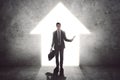 Young businessman standing near a bright door