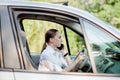 Picture of young businesswoman speaks by phone and doing makeup while driving a car in the traffic jam