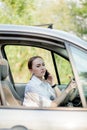 Picture of young businesswoman speaks by phone and doing makeup while driving a car in the traffic jam