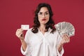 Confused beautiful woman holding money and credit card Royalty Free Stock Photo