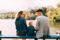 Picture of a young family in park looking at each other near a lake on a bench Royalty Free Stock Photo