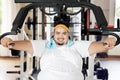 Smiling fat man exercises with a fitness machine Royalty Free Stock Photo