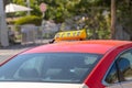 Picture of young man in cap and plaid shirt sitting in back seat in yellow taxi. Happy male getting into a cab