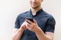 Picture of young man using a mobile smart phone and smiling Royalty Free Stock Photo