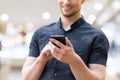 Picture of young man using a mobile smart phone and smiling Royalty Free Stock Photo