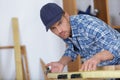 Picture young man working as carpenter and measuring board Royalty Free Stock Photo