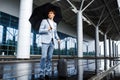 Picture of young redhaired businessman holding black umbrella and suitcase in rain at airport Royalty Free Stock Photo