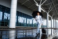 Picture of young redhaired businessman holding black umbrella and suitcase walking in rain at station Royalty Free Stock Photo