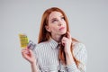 Picture of young redhead be lost in thought businesswoman in striped shirt with one pack of pills thinking white Royalty Free Stock Photo