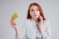 Picture of young redhead businesswoman in striped shirt with one pack of pills white background studio Royalty Free Stock Photo