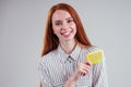 Picture of young redhead businesswoman in striped shirt with one pack of pills white background studio Royalty Free Stock Photo