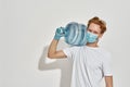 Picture of a young redhead deliveryman carrying a huge bottle of water