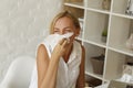 Picture of young blond sick woman blowing her nose
