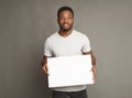 Picture of young african-american man holding white blank board Royalty Free Stock Photo