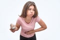 Picture of young woman hold eclair. She is going to puke. Model hold hand on stomach. She feels bad. Isolated on white