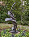 Abstract steel sculpture in a flower bed in front of a home in Dallas, Texas