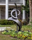 Abstract steel sculpture in a flower bed in front of a home in Dallas, Texas