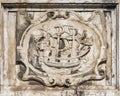 Ancient engraved stone relief in Lisbon with a sailboat and two ravens/
