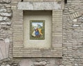 Art piece featuring Mary, Joseph, Jesus and a lamb in an outside wall niche on a street in Assisi, Italyaaly.