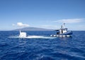 Atlantis IV submarine submerging, and submarine support vessel `Roxie` in the Pacific Ocean off the Island of Maui in Hawaii. Royalty Free Stock Photo