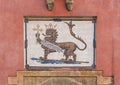 Azuela with Crowned lion holding cross standing on a spear above the entry door to the Royal Alcazar Palace in Seville, Spain.