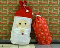 Santa Bag and Christmas bag with Merry Christmas wallpaper in the background on display in Lambert International Airport