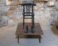 Black empty chair with feet sculpture by Nino Longobardi in a room of the Castel Del Monte