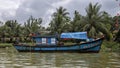 Blue working fishing boat anchored along the bank of the Thu Bon River in Hoi An, Vietnam