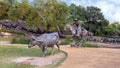 Bronze cowboy on horseback with steers in the background in the Pioneer Plaza, Dallas, Texas.