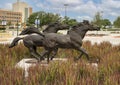 Scupture featuring two bronze horses running through tall grass at the University of Texas at Arlington.