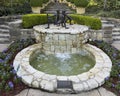 \'Chico y Chica de la Playa\' by Victor Salmones atop a fountain in a garden in the Dallas Arboretum. Royalty Free Stock Photo