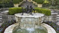 \'Chico y Chica de la Playa\' by Victor Salmones atop a fountain in a garden in the Dallas Arboretum.