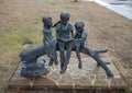 A bronze sculpture titled `Children Reading` by unknown artist located in the Dr. Glenn Mitchell Memorial Park in McKinney, Texas.